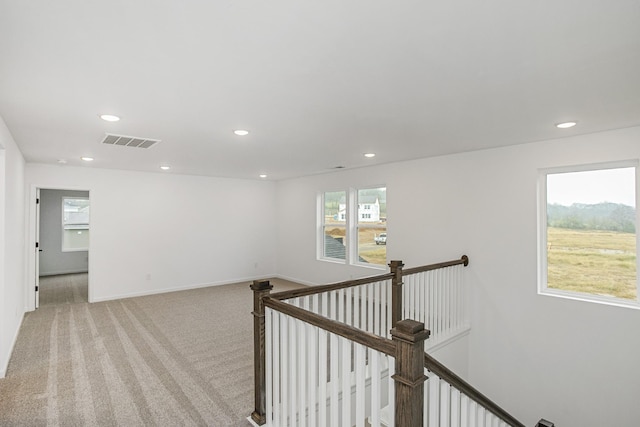 hall featuring recessed lighting, visible vents, light carpet, an upstairs landing, and baseboards