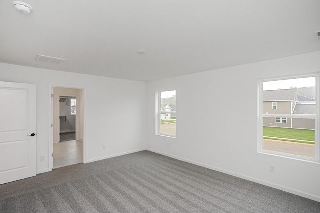 carpeted empty room featuring baseboards