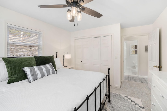 bedroom with ceiling fan, a closet, baseboards, and light colored carpet