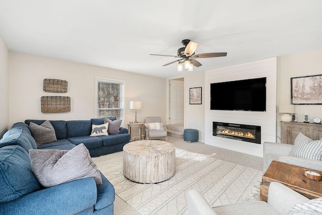 living room with ceiling fan, a fireplace, and light colored carpet