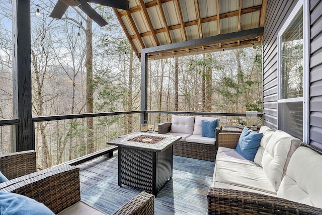 deck featuring ceiling fan and an outdoor living space with a fire pit