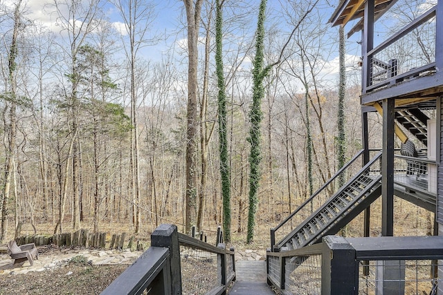 view of yard featuring stairway and a wooded view