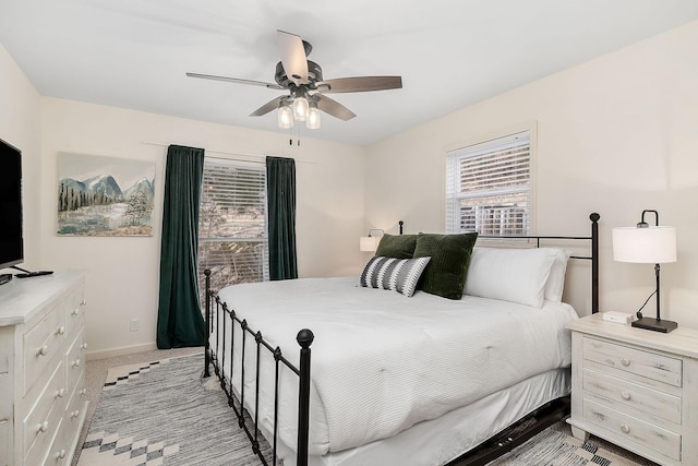 bedroom featuring baseboards, a ceiling fan, and light colored carpet