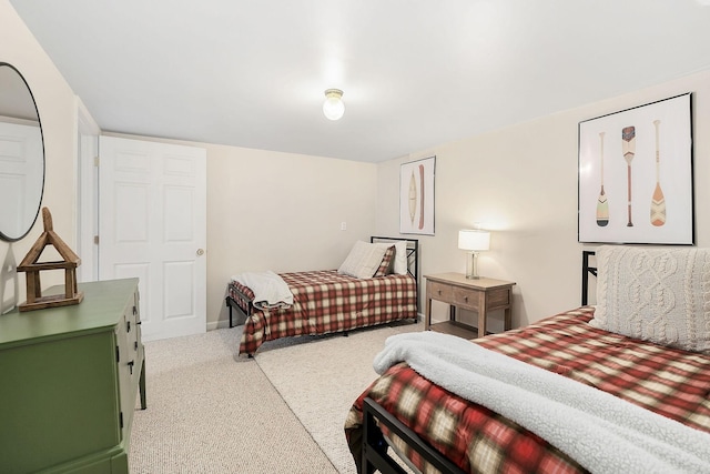 bedroom with light colored carpet and baseboards