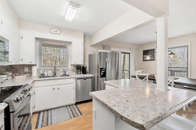 kitchen featuring stainless steel appliances, a sink, and white cabinetry