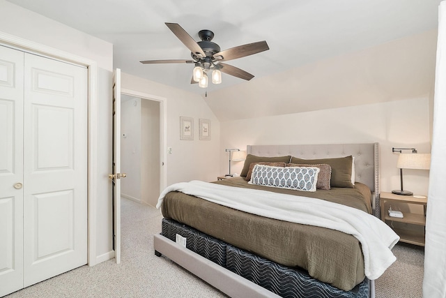 bedroom featuring lofted ceiling, light colored carpet, a ceiling fan, baseboards, and a closet