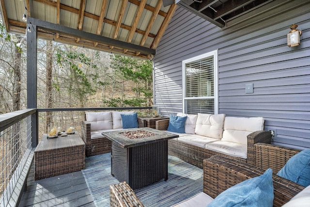 wooden terrace with an outdoor living space with a fire pit