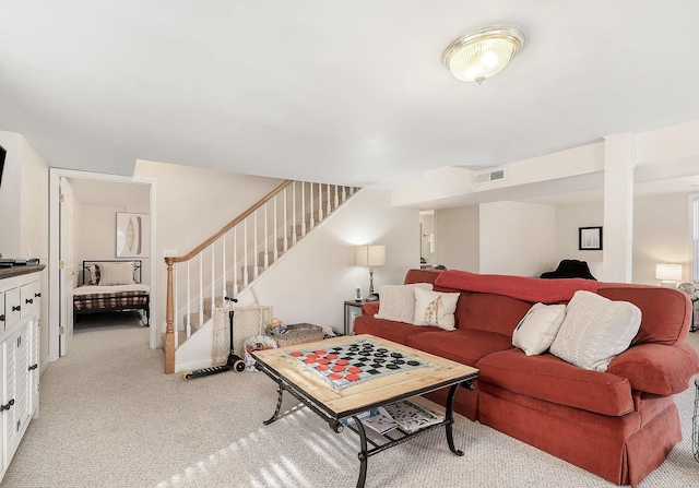 living room featuring light carpet, stairway, and visible vents