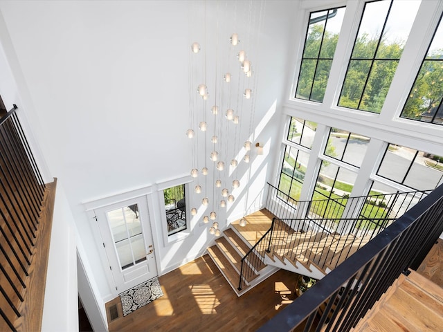 entrance foyer with a high ceiling, stairway, and wood finished floors