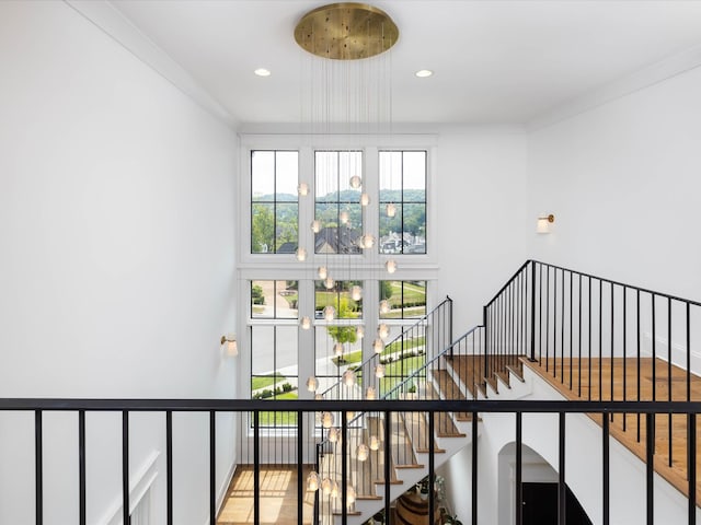 stairs with crown molding and recessed lighting