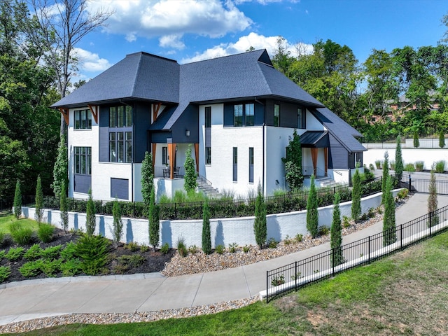 view of home's exterior featuring a fenced front yard and a shingled roof