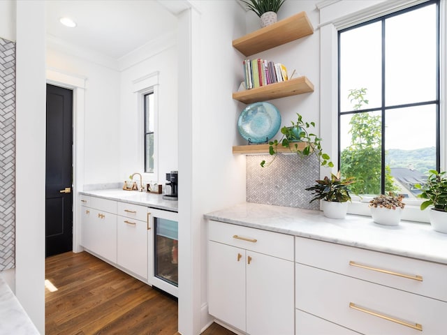 bar with recessed lighting, beverage cooler, dark wood-type flooring, a sink, and backsplash