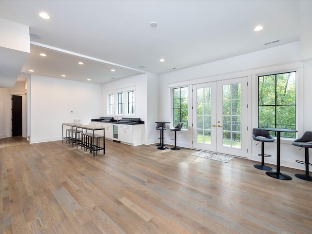 interior space featuring light wood-type flooring, recessed lighting, french doors, and visible vents