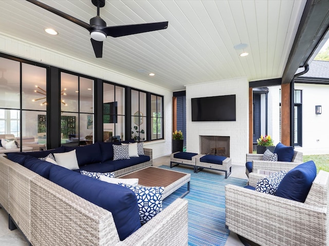 view of patio / terrace featuring ceiling fan and an outdoor living space with a fireplace