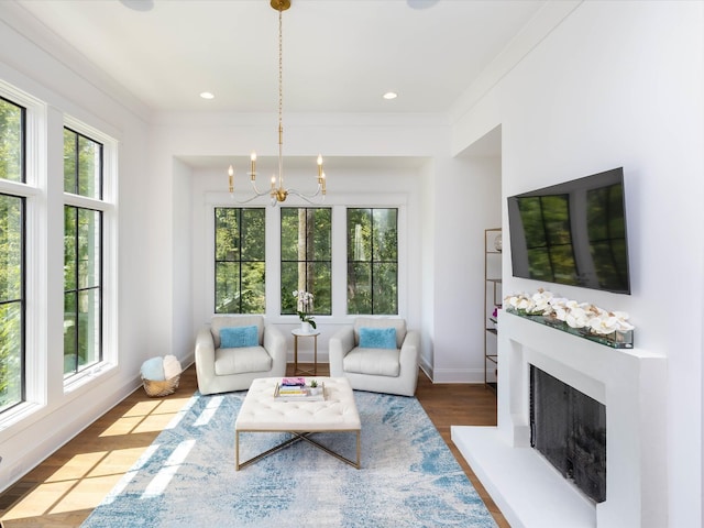 living room featuring a fireplace with raised hearth, recessed lighting, wood finished floors, baseboards, and an inviting chandelier