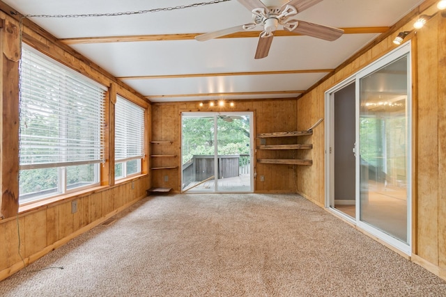 interior space with built in features, beam ceiling, wood walls, and ceiling fan