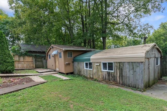 rear view of house featuring a yard and fence