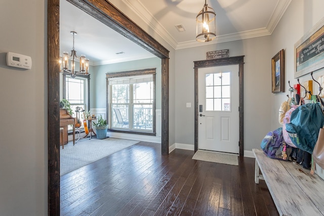 foyer featuring crown molding, dark wood-style floors, and an inviting chandelier