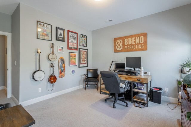 office space featuring light colored carpet, visible vents, and baseboards