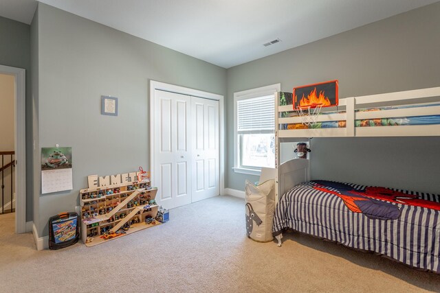 bedroom with a closet, carpet, visible vents, and baseboards