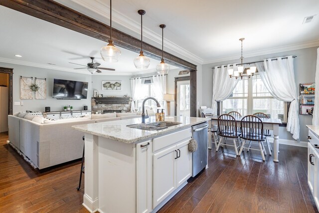 kitchen featuring light stone counters, a sink, white cabinets, dishwasher, and a center island with sink