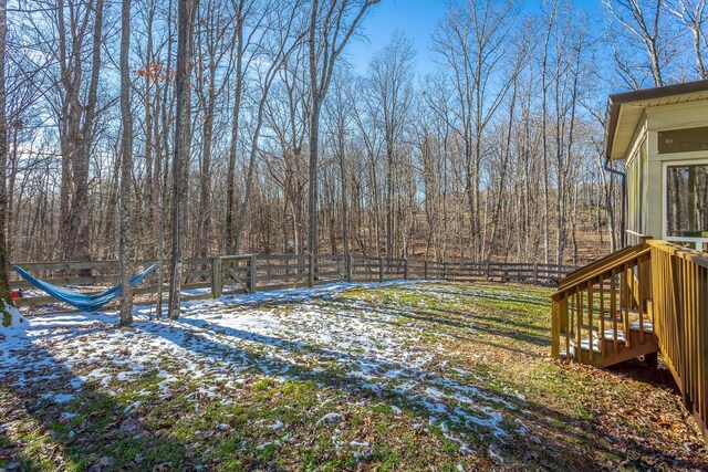 snowy yard with a fenced backyard