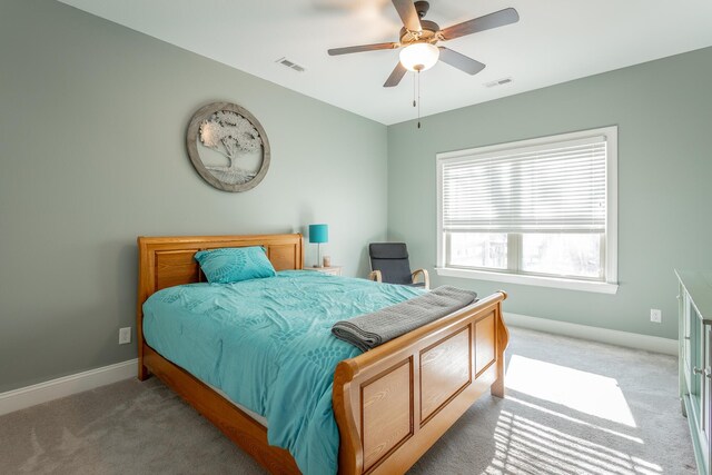 carpeted bedroom featuring a ceiling fan, visible vents, and baseboards