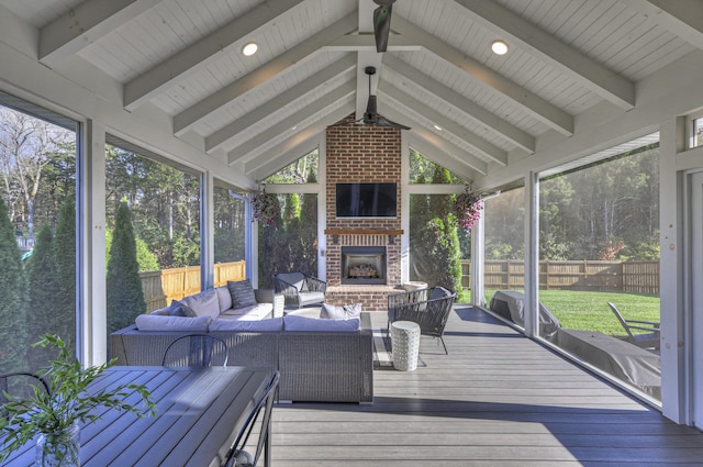 sunroom featuring an outdoor brick fireplace and vaulted ceiling with beams