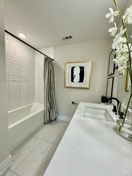 bathroom with baseboards, visible vents, shower / tub combo with curtain, marble finish floor, and vanity