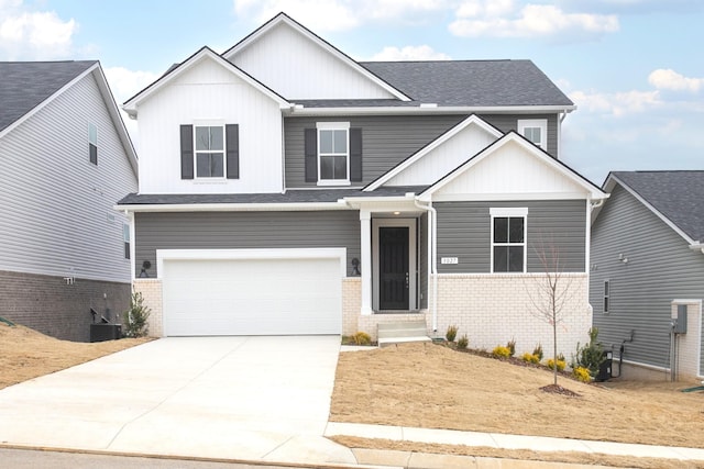 view of front facade featuring driveway, brick siding, a shingled roof, a garage, and board and batten siding