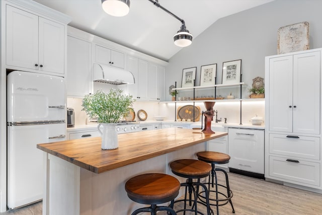 kitchen featuring white cabinets, dishwashing machine, fridge, open shelves, and wooden counters