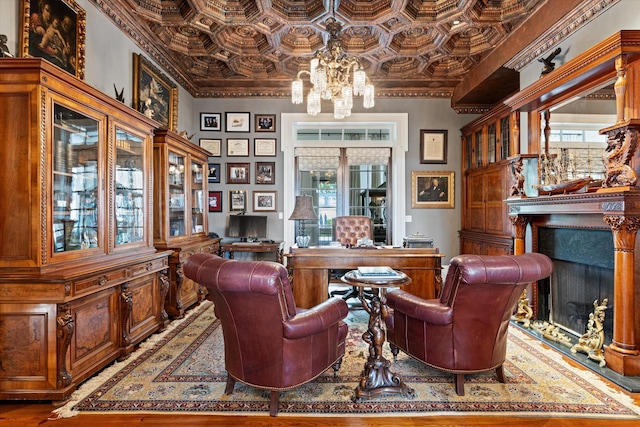 living area featuring an ornate ceiling, a chandelier, a fireplace, and ornamental molding