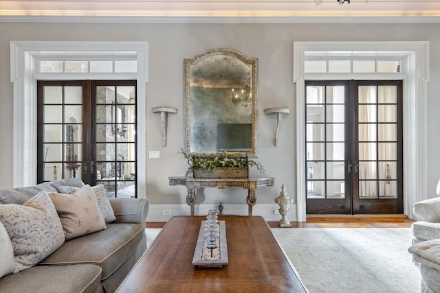 living room featuring ornamental molding, french doors, baseboards, and wood finished floors