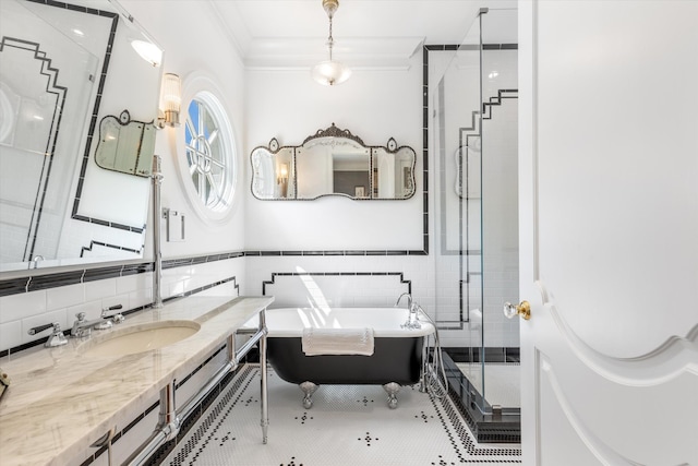 bathroom with crown molding, tile walls, a stall shower, vanity, and a freestanding tub