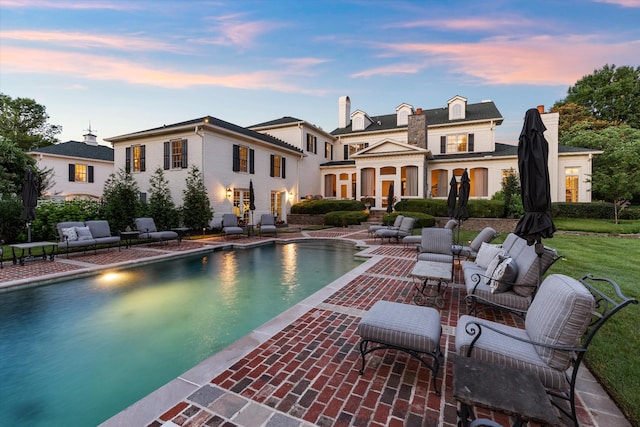 rear view of property with a patio area and an outdoor pool