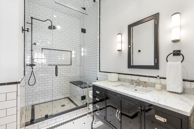 bathroom featuring a shower stall, tile walls, and vanity