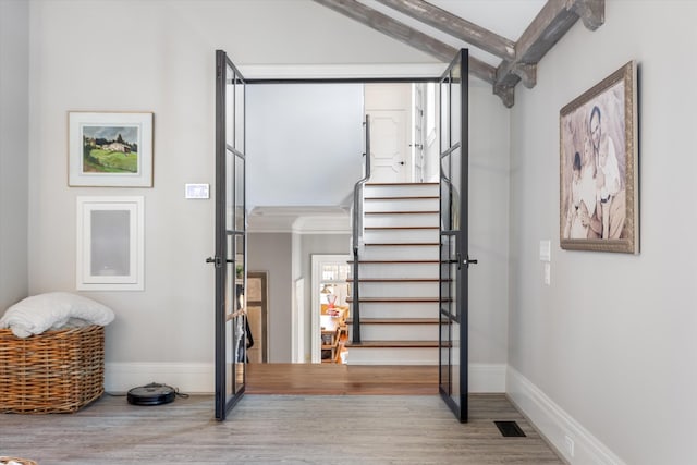 interior space with beamed ceiling, wood finished floors, and baseboards