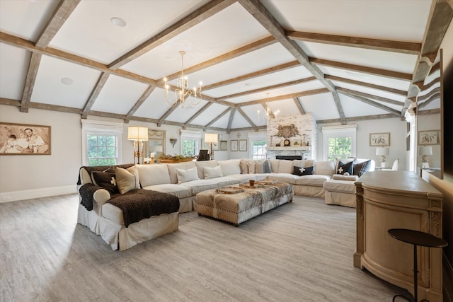 living area featuring light wood finished floors, a wealth of natural light, and an inviting chandelier