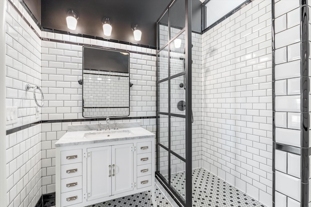 bathroom featuring vanity, a tile shower, and tile walls