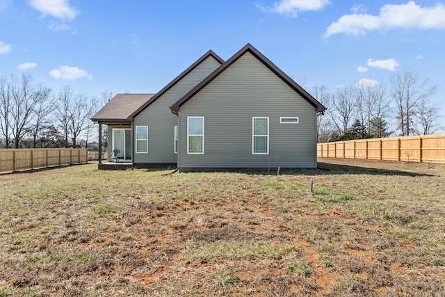 back of house featuring a fenced backyard and a yard