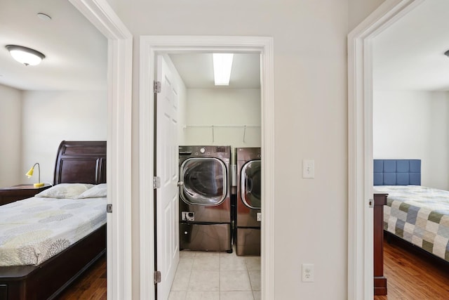 clothes washing area featuring laundry area, light wood-style flooring, and washing machine and clothes dryer