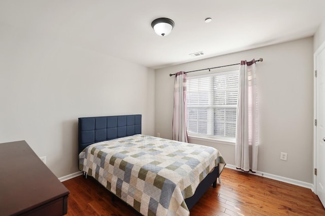 bedroom featuring dark wood-style flooring, visible vents, and baseboards