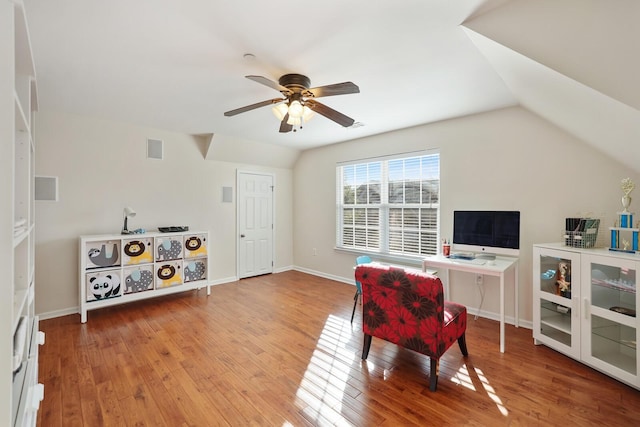 home office with a ceiling fan, visible vents, vaulted ceiling, and wood finished floors