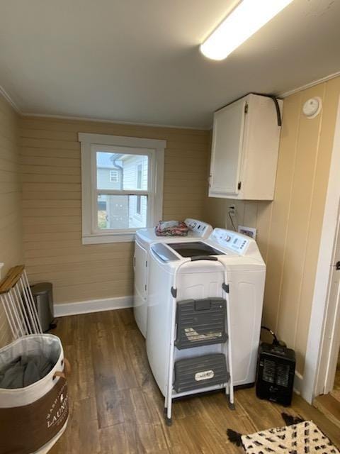 clothes washing area featuring cabinet space, independent washer and dryer, baseboards, and wood finished floors