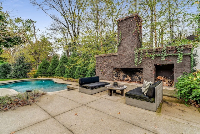 pool with an outdoor stone fireplace, grilling area, and a patio