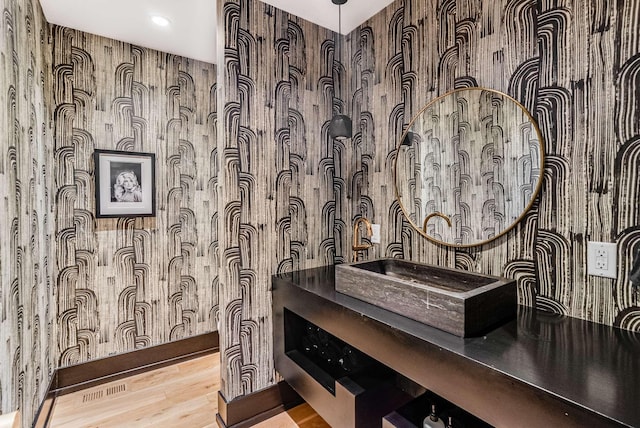 bathroom with visible vents, vanity, and wood finished floors