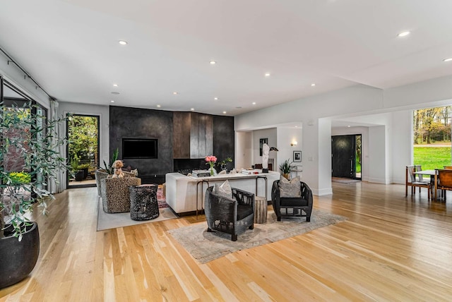 living room featuring light wood-style flooring, baseboards, and recessed lighting