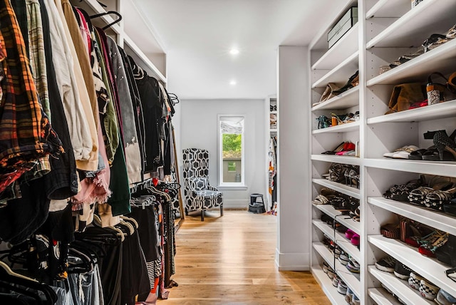 walk in closet with light wood-style flooring