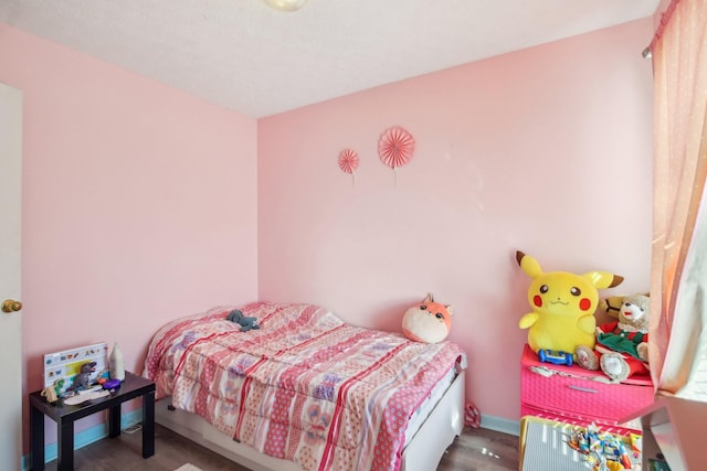 bedroom with baseboards and wood finished floors