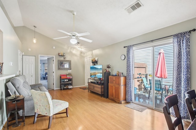 living area featuring visible vents, light wood-style floors, a ceiling fan, vaulted ceiling, and baseboards